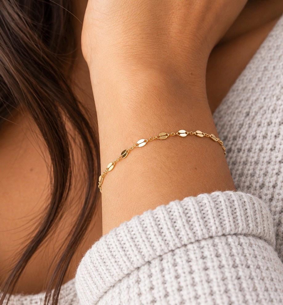 Dainty gold plated faceted bracelet worn with cream knit sleeve
