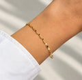 Delicate 14K gold plated faceted chain bracelet worn on wrist with white sleeve
