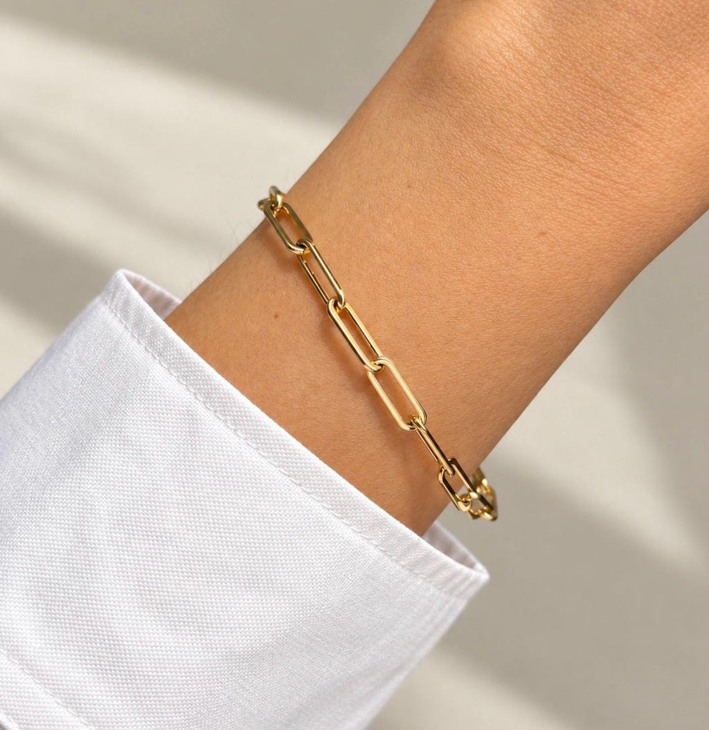 14K gold plated paperclip chain bracelet worn on wrist with white shirt