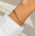 14K gold plated paperclip chain bracelet worn on wrist with white shirt