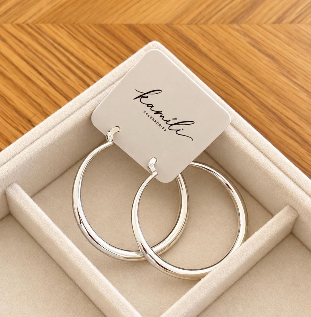 Large silver hoop earrings on Kamíli Accessories branded jewellery card