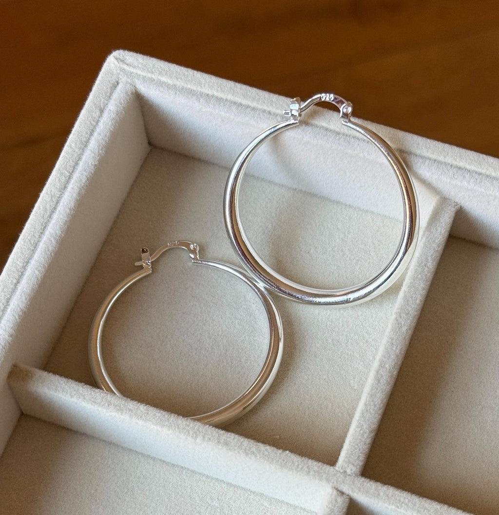 Sterling silver hoop earrings in cream fabric jewellery tray