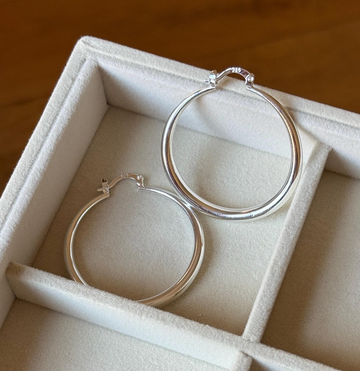 Sterling silver hoop earrings in cream fabric jewellery tray