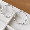 Large sterling silver hoops displayed separately in a velvet jewellery tray