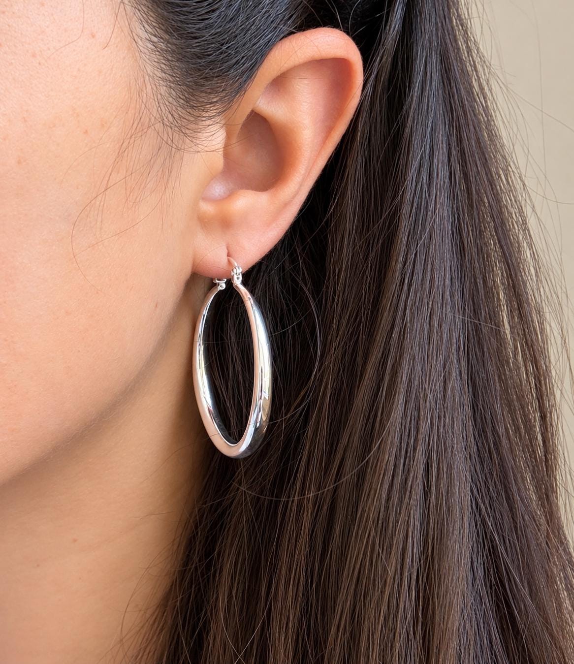 40mm polished sterling silver hoop earring worn on ear