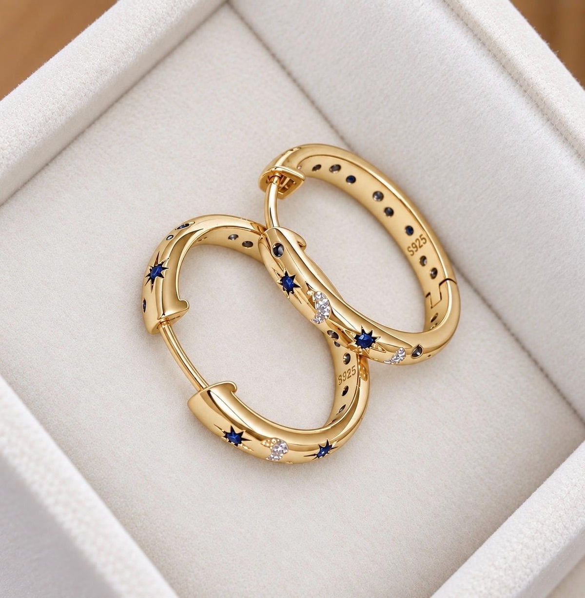 Open gold-plated sterling silver celestial hoop earrings with blue stars and crescent moon pattern