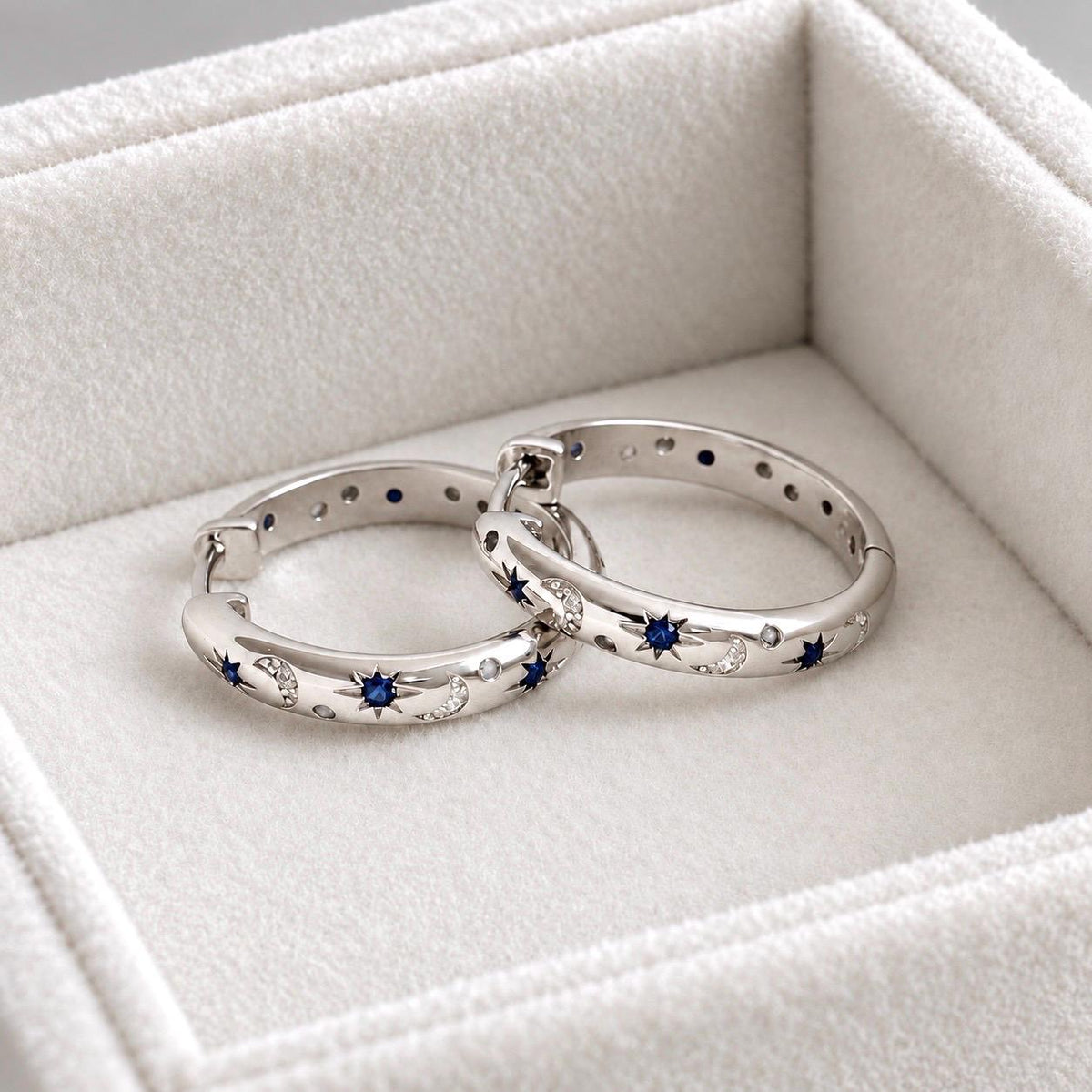 Sterling silver celestial blue star and moon CZ hoop earrings on velvet