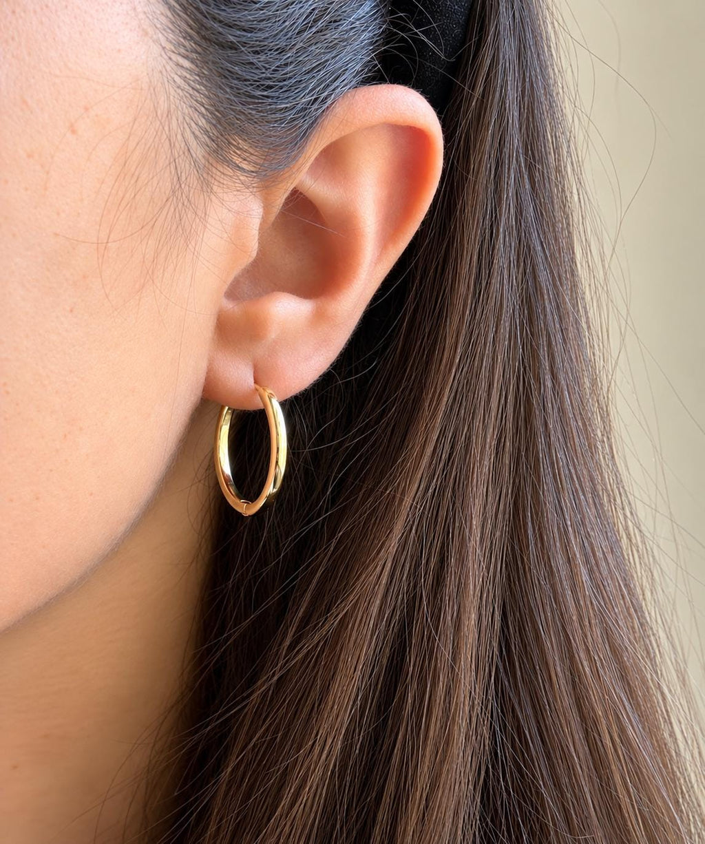 Gold plated classic sterling silver hoop earring worn on ear