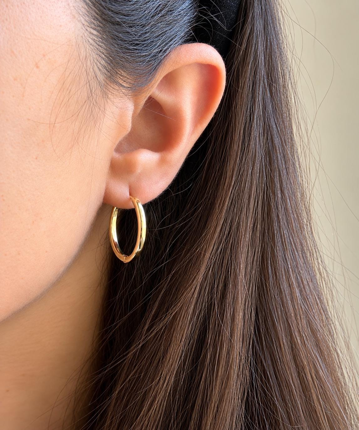 Gold plated classic sterling silver hoop earring worn on ear