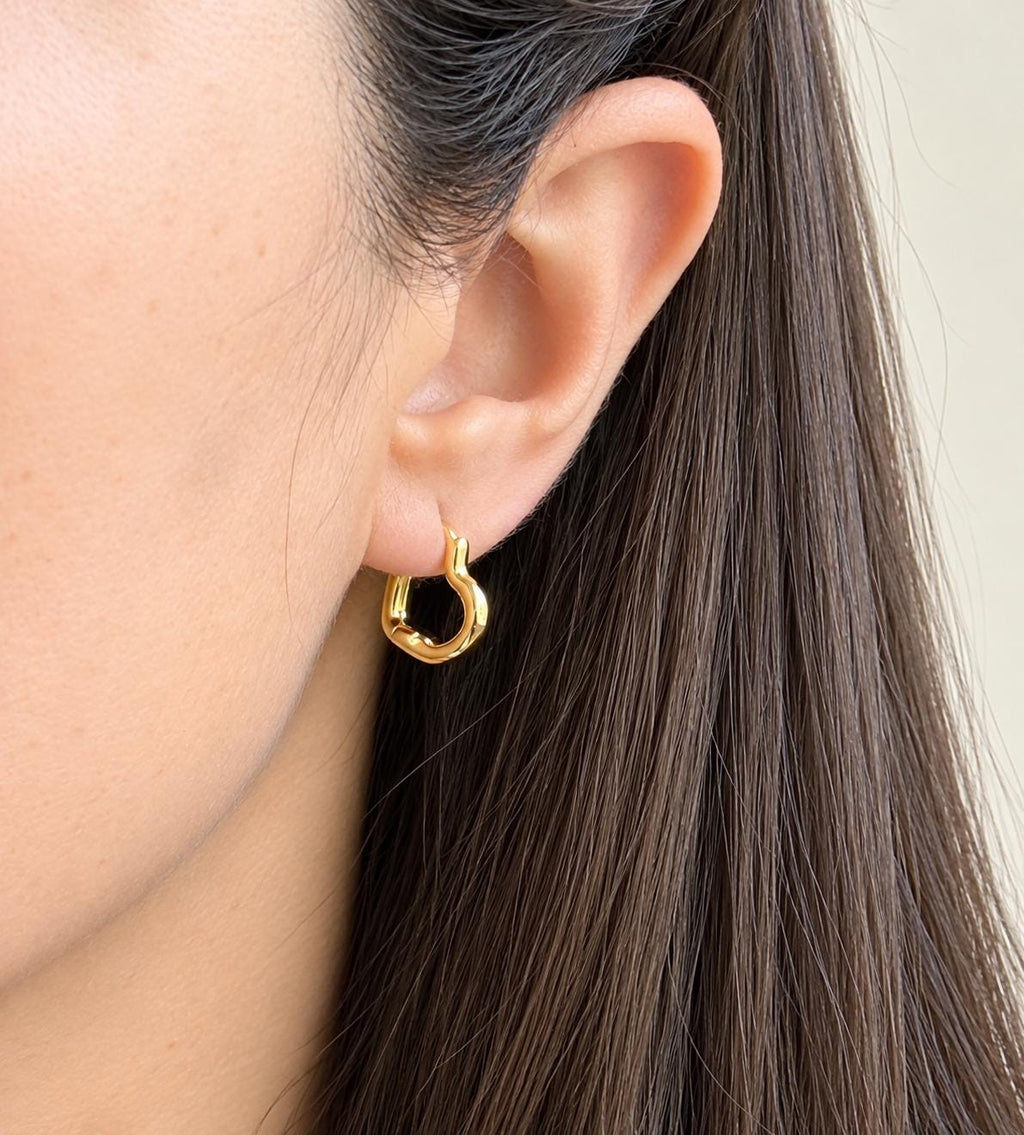 Small gold plated open heart hoop earring worn on the ear