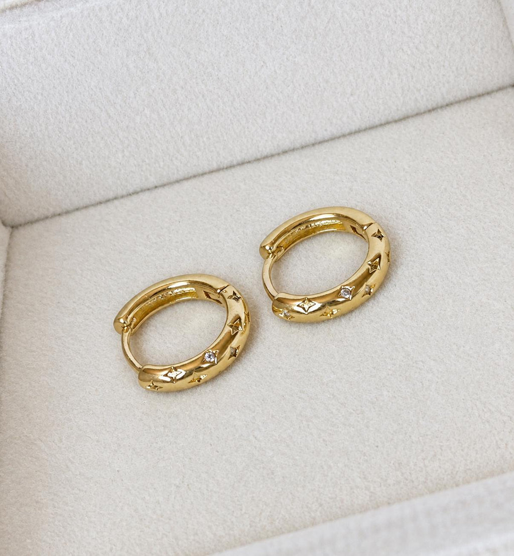 Pair of 18K gold plated 925 sterling silver star engraved CZ huggie hoops in ivory velvet jewellery box