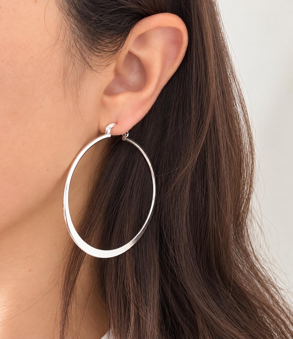 Model wearing large 55mm polished sterling silver hoop earring