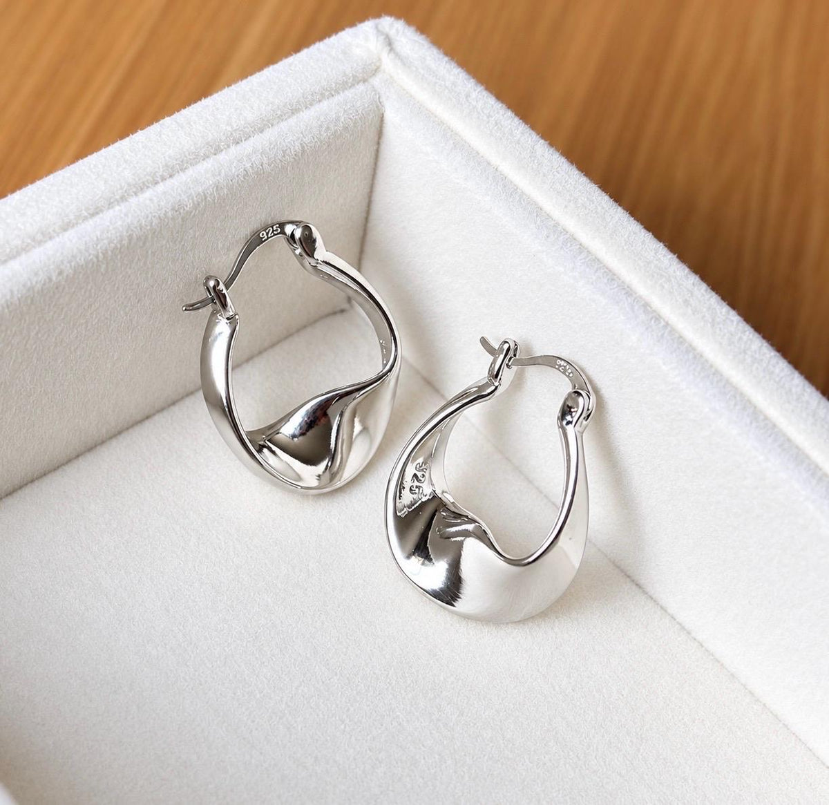 Detail view of 925 sterling silver earrings with curved organic teardrop design