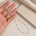 925 sterling silver rainbow beaded necklace with small red blue green yellow and black beads held in hand