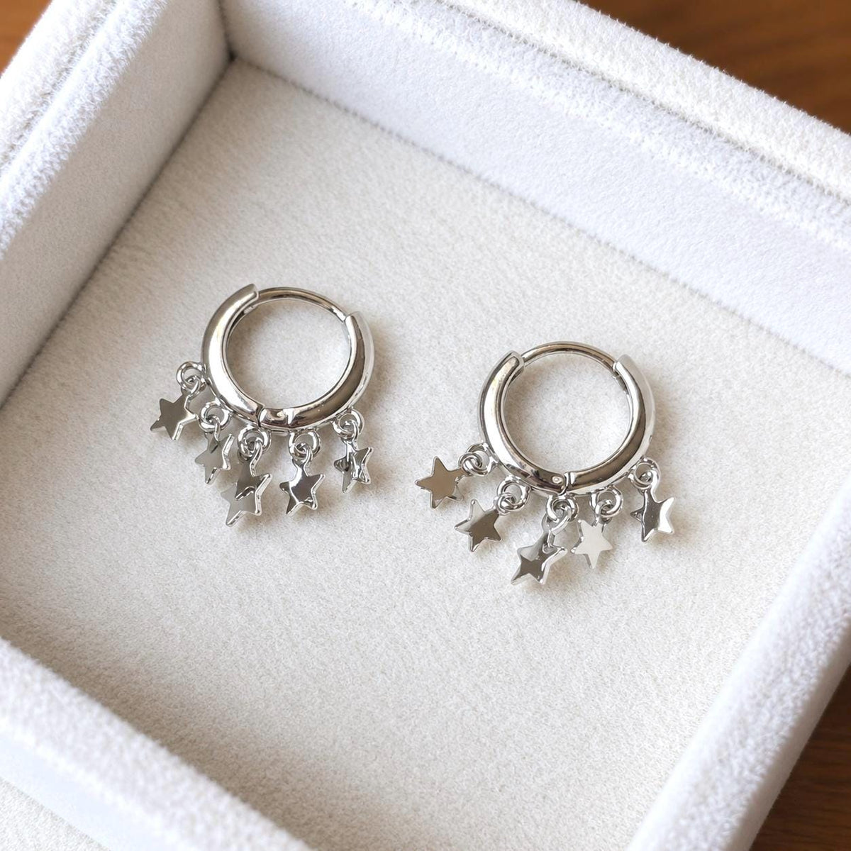 925 sterling silver star charm huggie earrings on ivory velvet