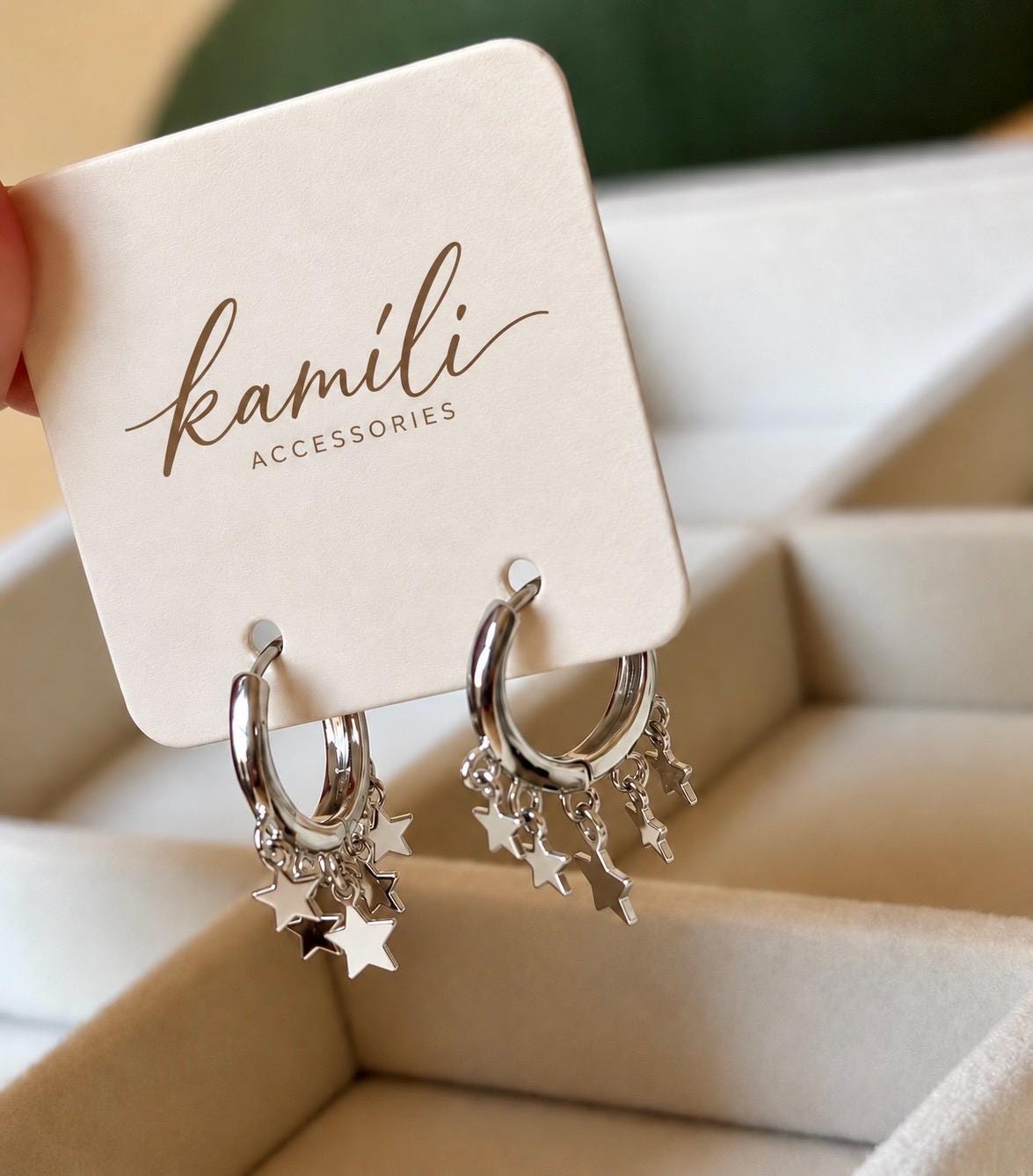 Sterling silver celestial star hoops on Kamíli Accessories branded card