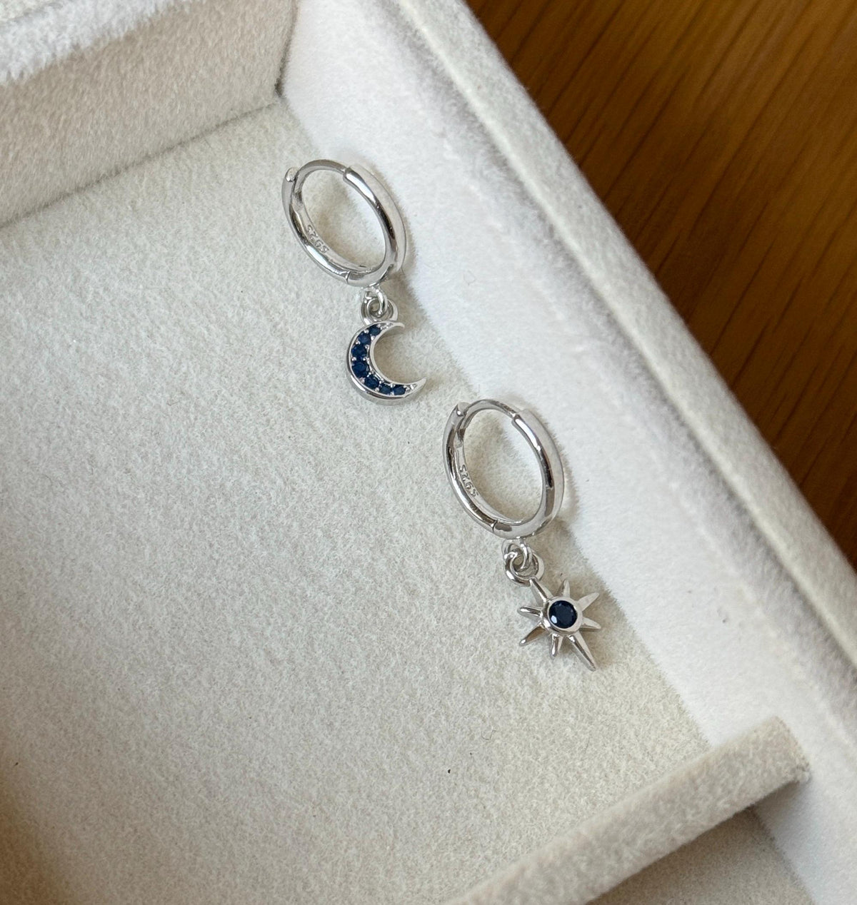 Sterling silver moon and star hoops with blue stones, showing 925 marking
