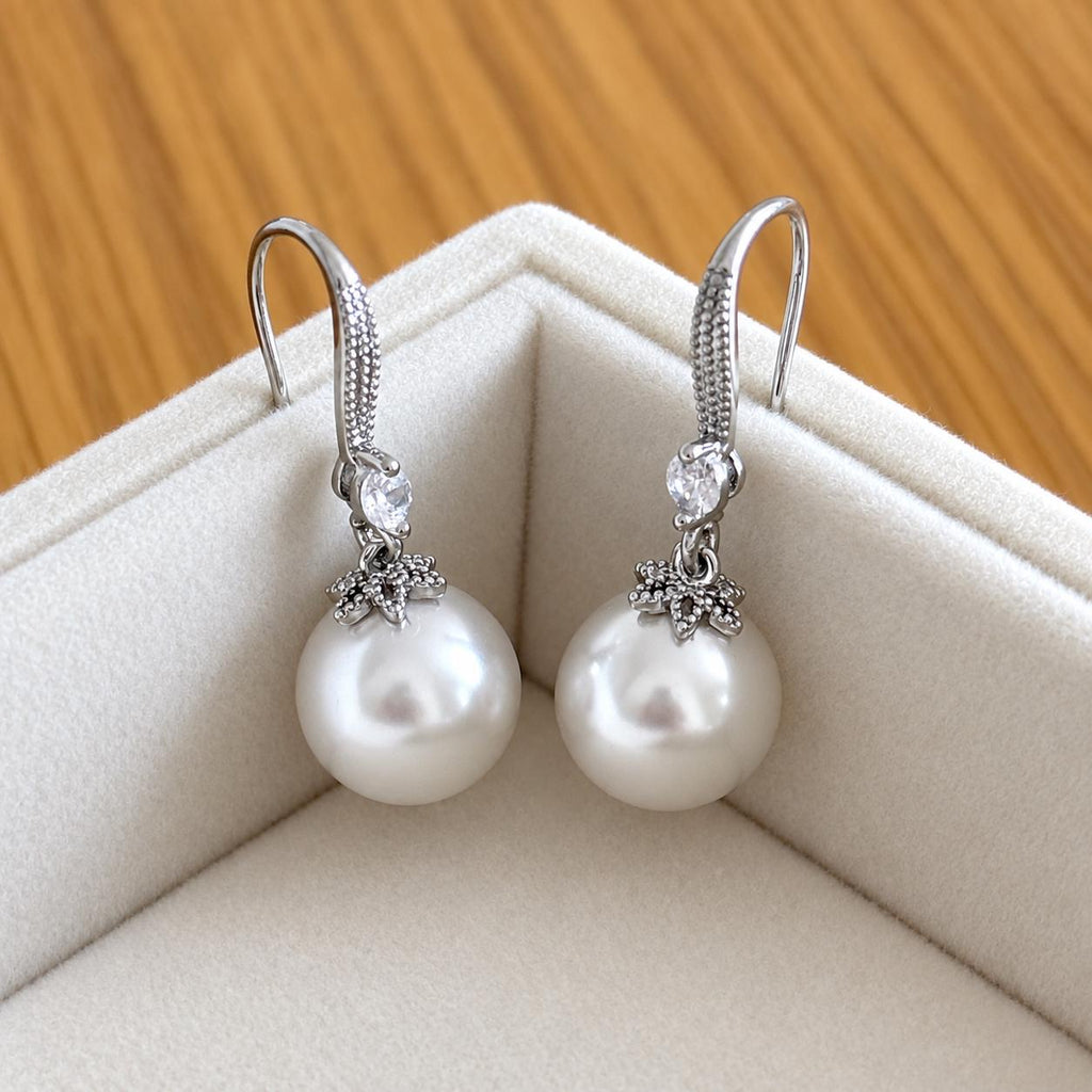 Pair of fine silver white pearl drop earrings with clear sparkling accents in an ivory jewellery box