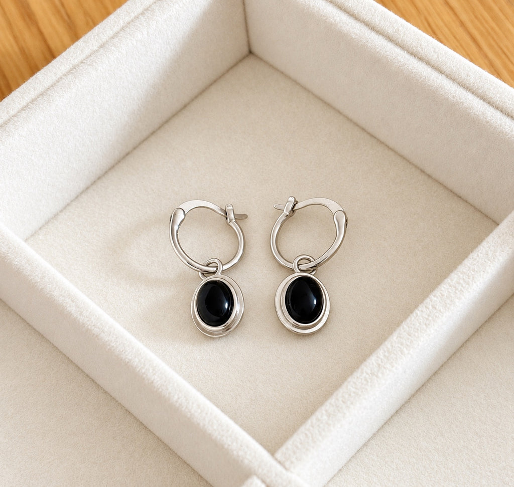 Front view of silver hoops with oval black agate drops