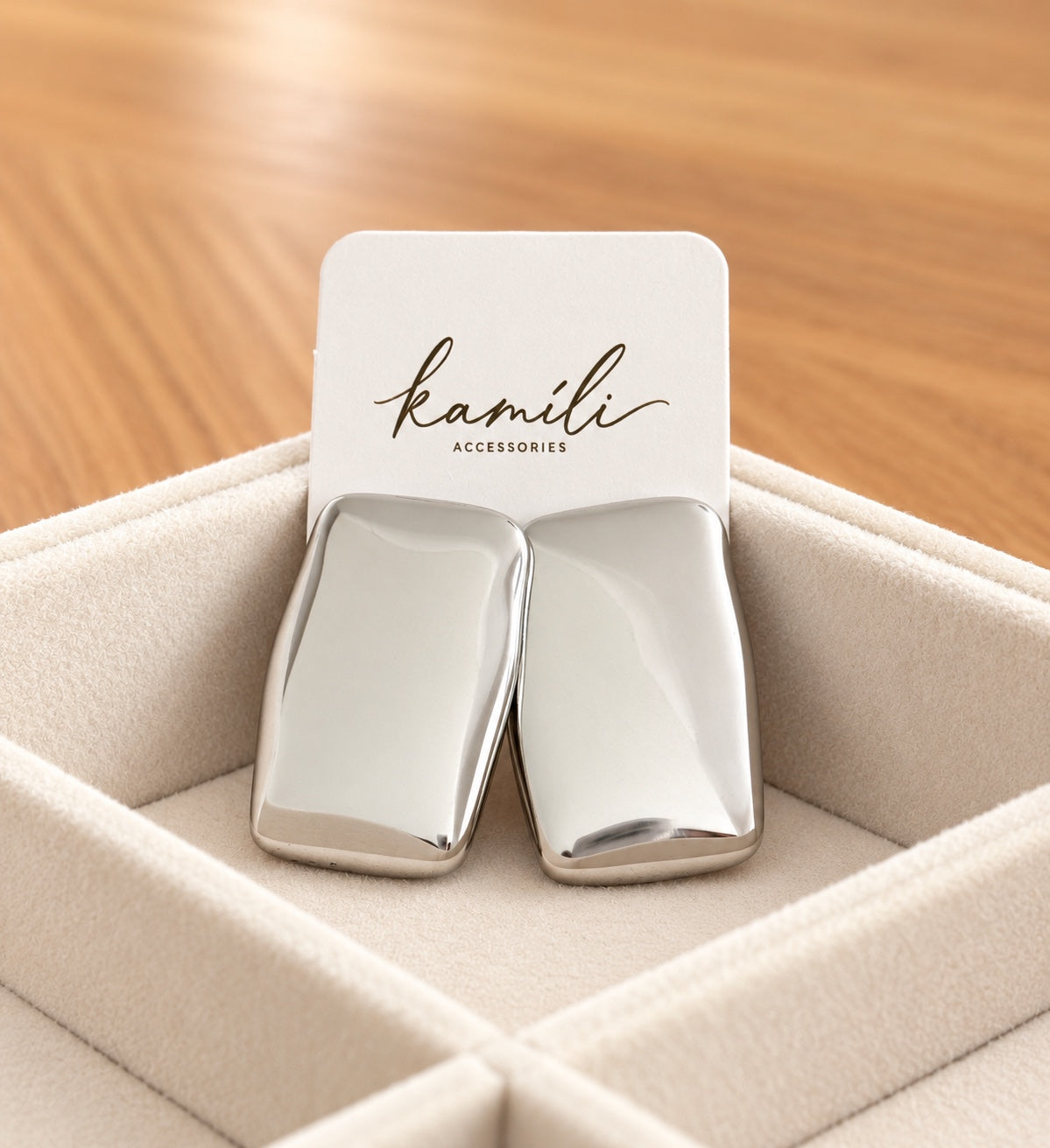 Polished silver rectangle stud earrings displayed with Kamíli Accessories branded card