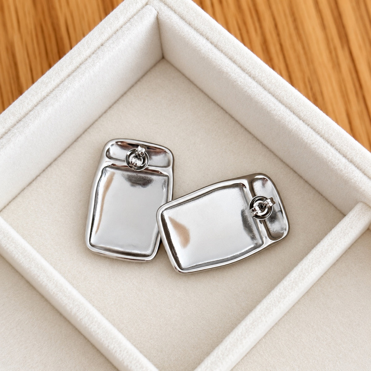Reverse view of rectangular silver-tone stainless steel earrings showing stud posts and butterfly backs