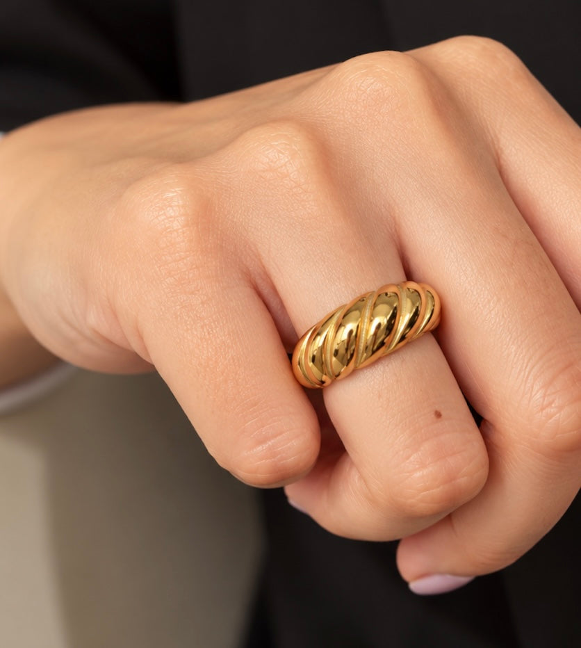 Gold plated chunky ribbed croissant ring worn on a hand closeup