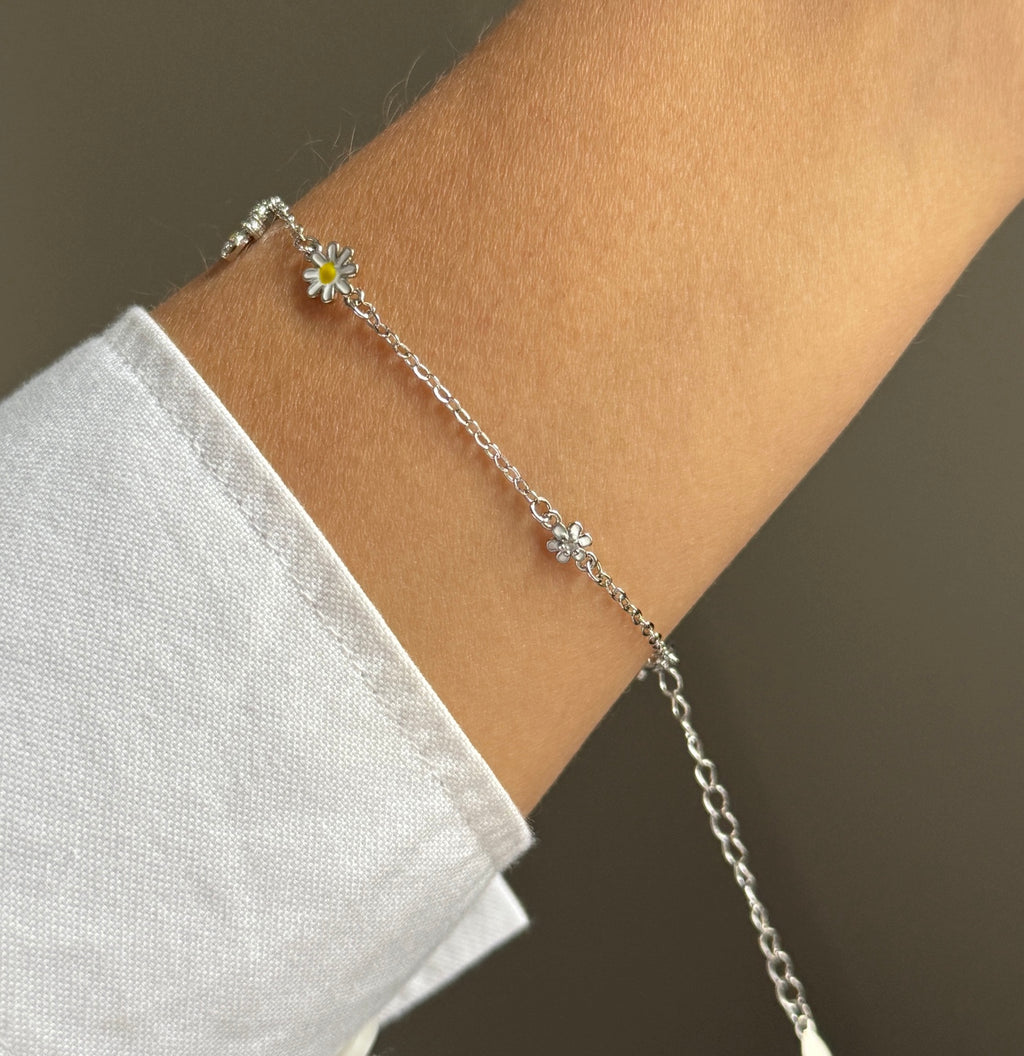 Detail view of floral charms and extender chain worn on wrist