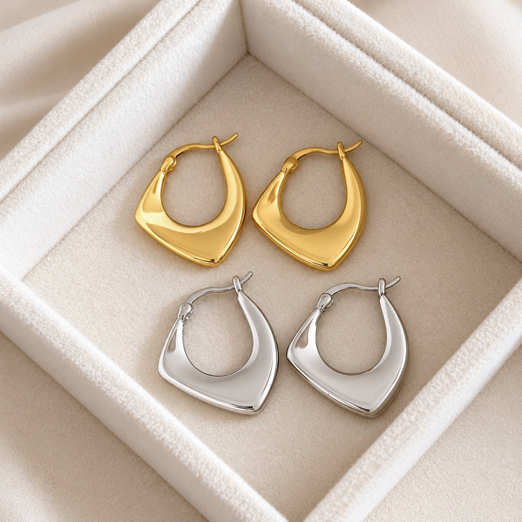 Gold and silver geometric 925 sterling silver hoop earrings together on a cream jewellery tray