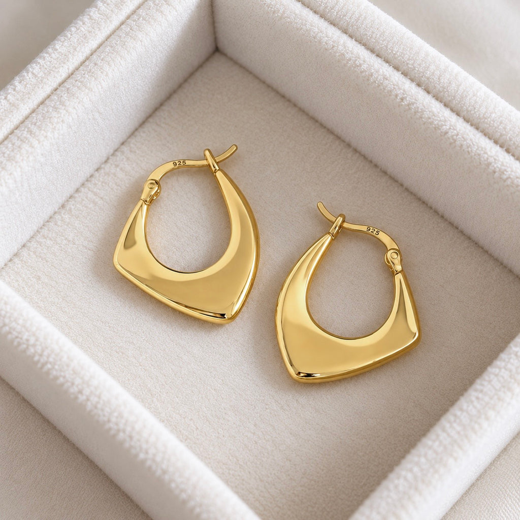 Gold colour 925 sterling silver geometric hoop earrings on cream jewellery tray