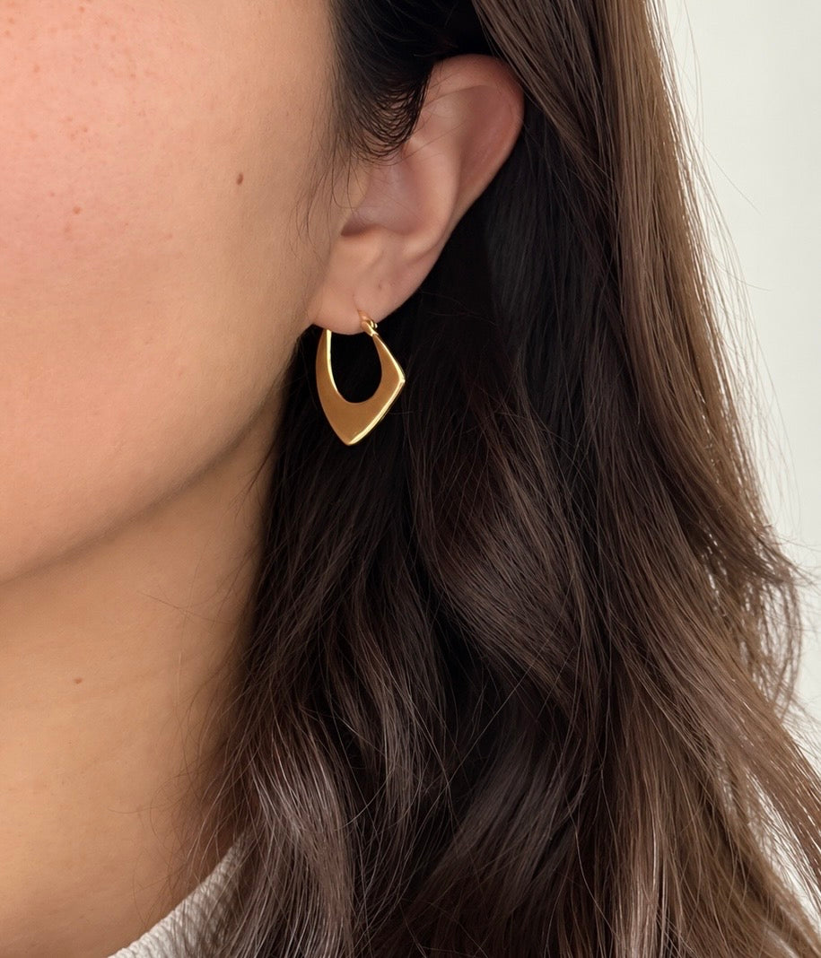 Model wearing a gold colour geometric hoop earring