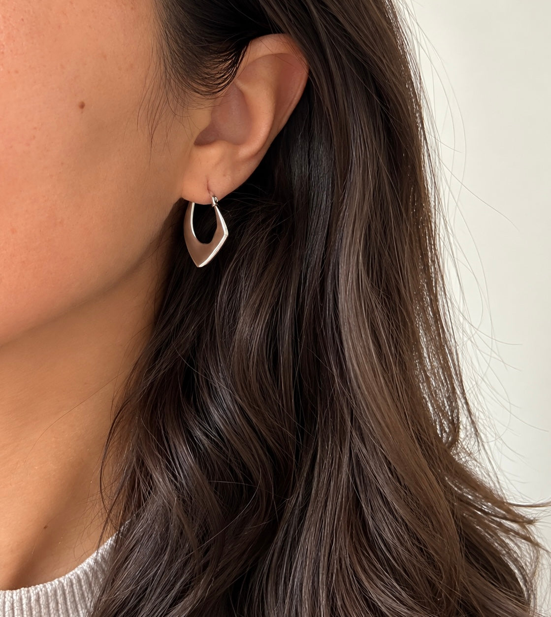 Model wearing a silver colour geometric hoop earring