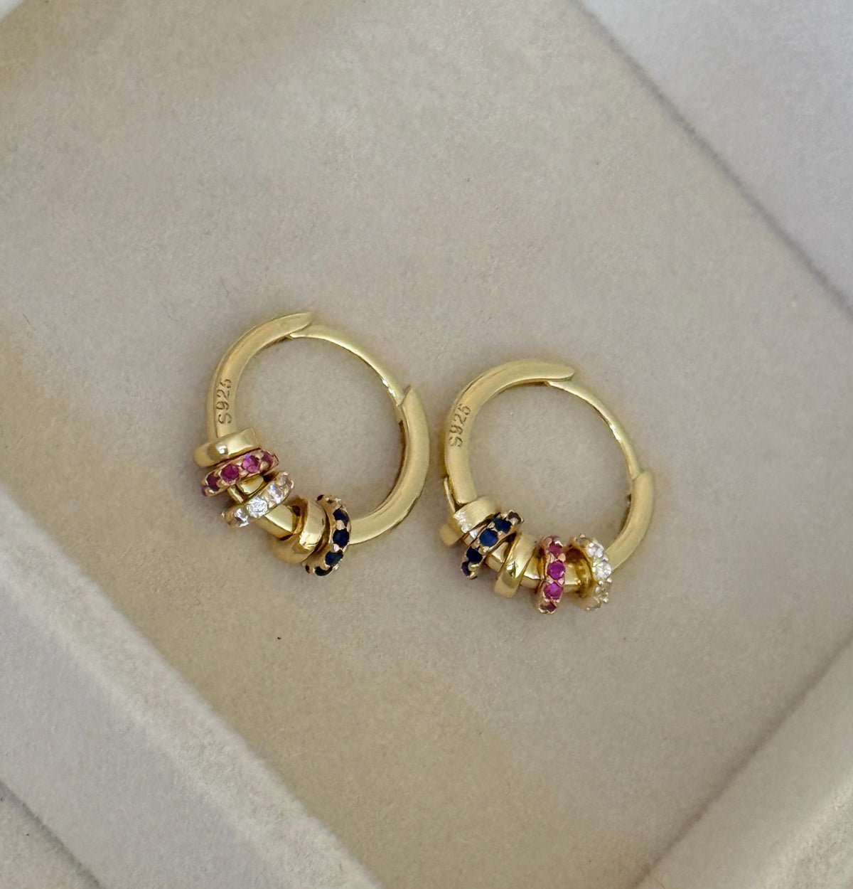 Close-up of gold beaded hoop earrings showing S925 sterling silver stamp