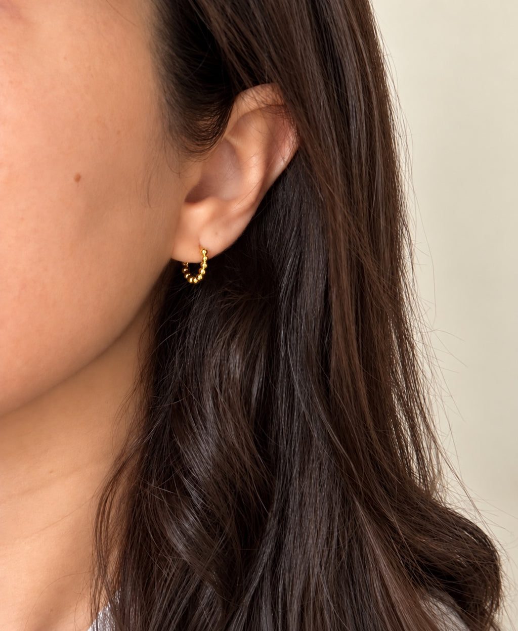 Small gold beaded hoop worn on ear
