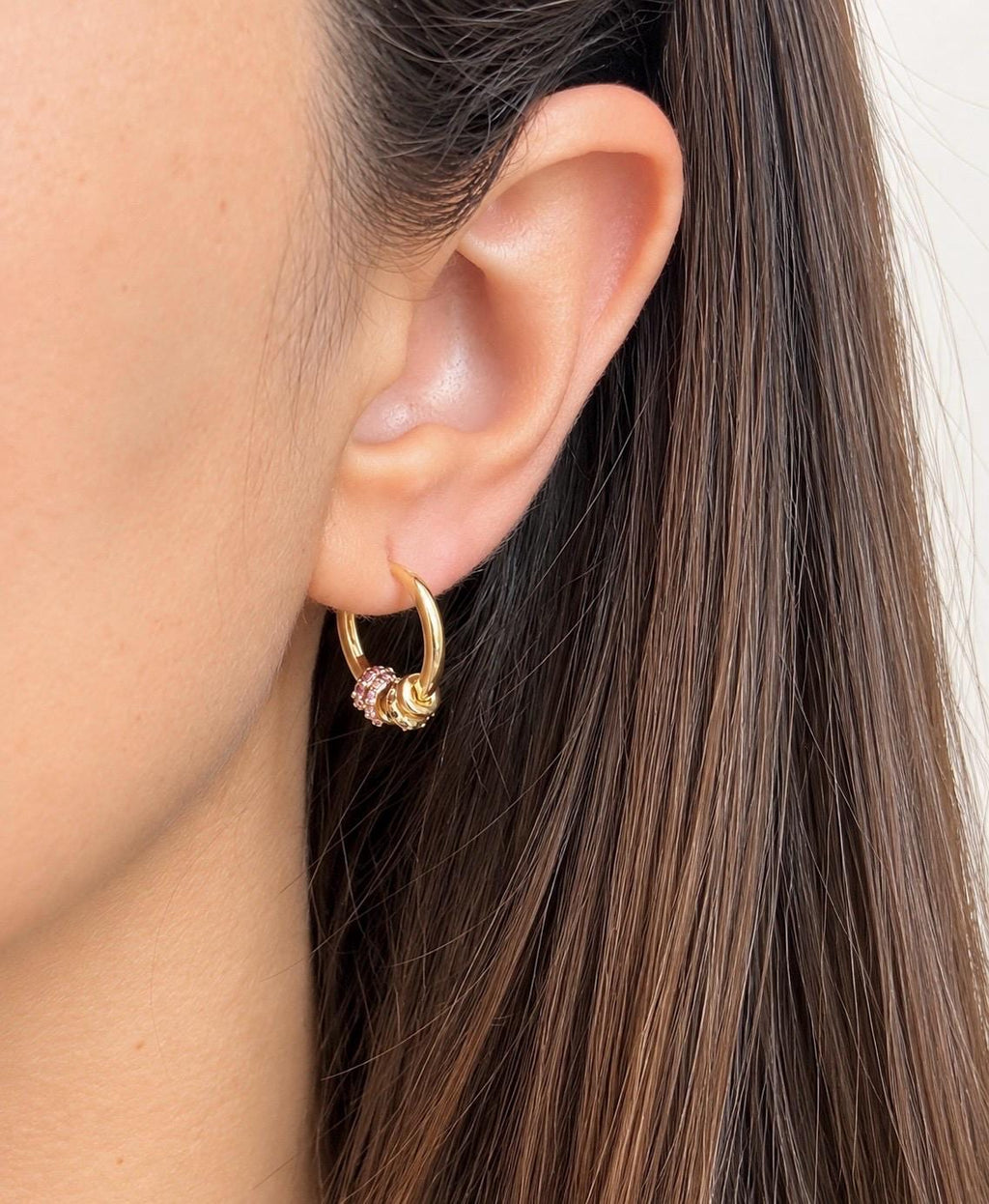 Gold plated multicolour CZ beaded hoop earring worn on the ear