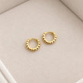 Pair of petite gold coloured 925 silver beaded hoops on cream velvet