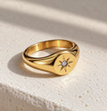 18K gold-plated celestial North Star signet ring with a sparkling clear CZ centre on cream stone