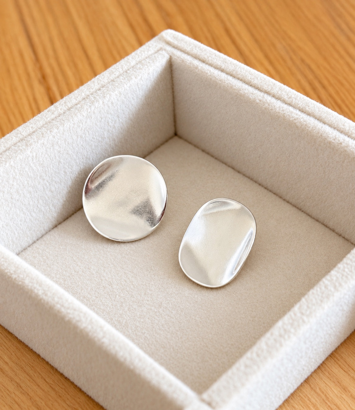 Silver organic disc stud earrings from an angled view
