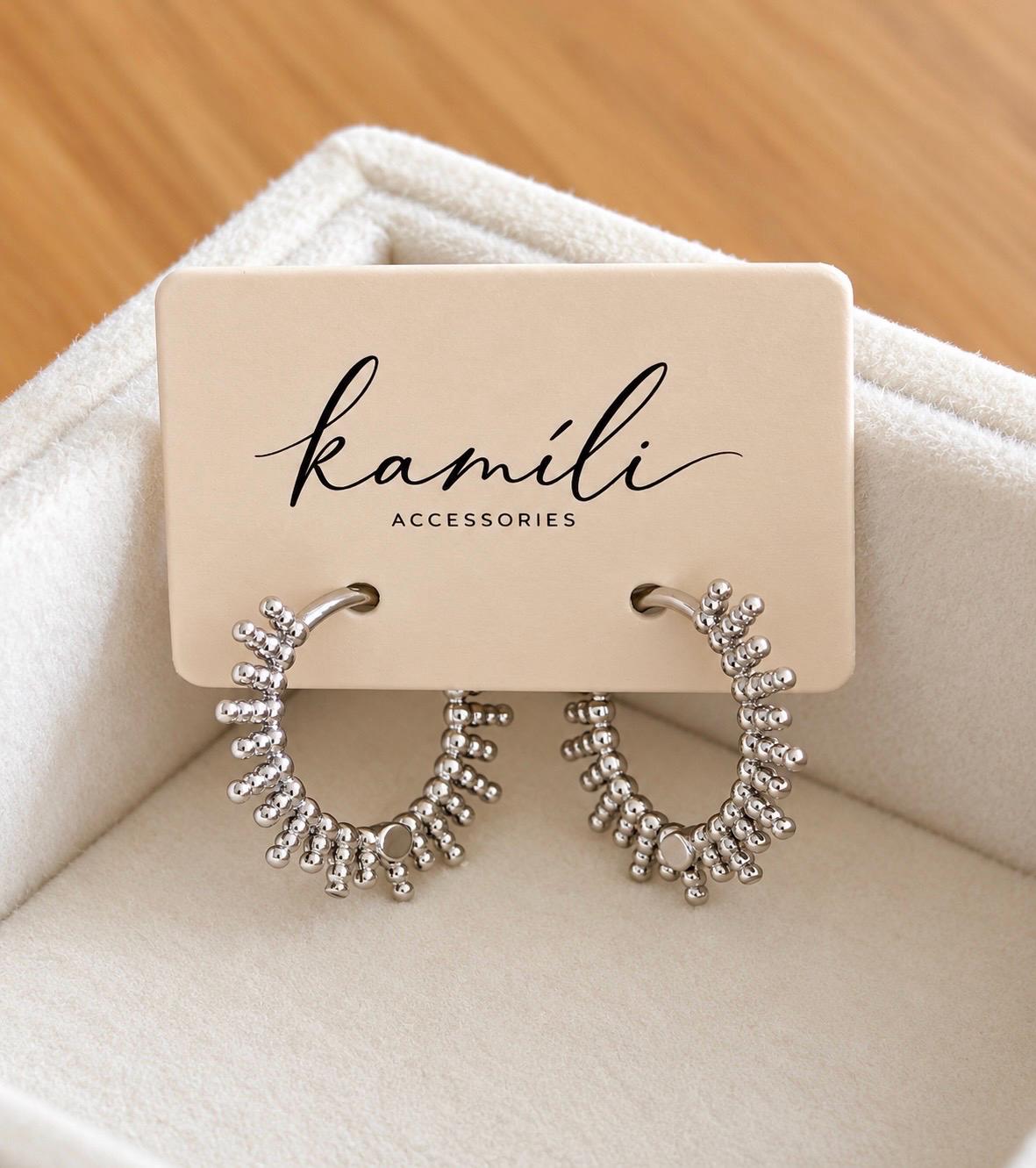 Silver sunburst hoop earrings displayed on Kamíli Accessories jewellery card