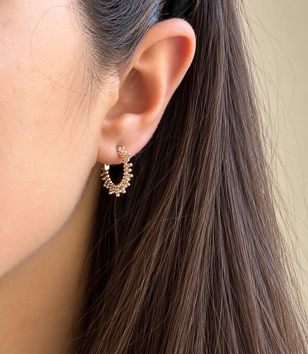 Model wearing a beaded sunburst hoop earring