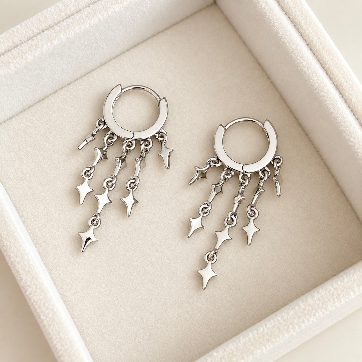 Star dangle hoops with multiple silver charms displayed at an angle