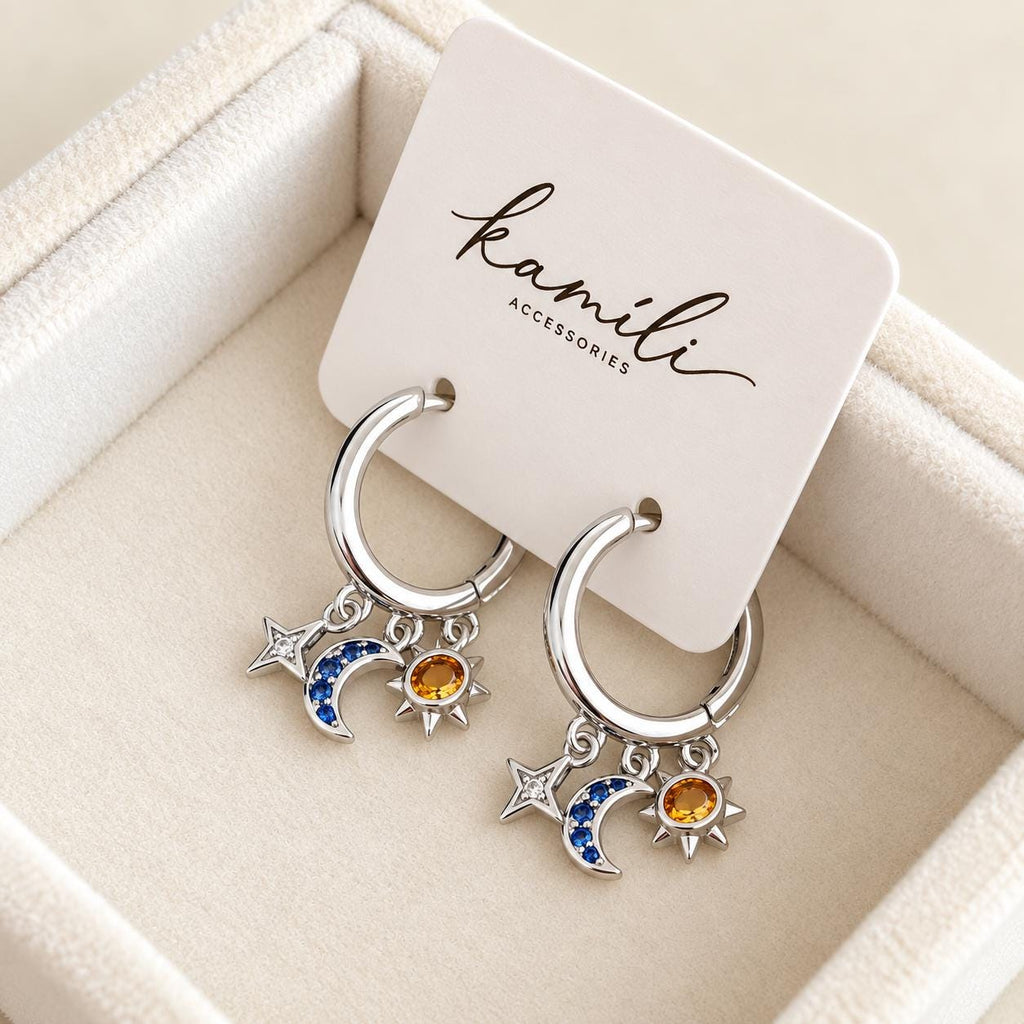 Pair of celestial CZ charm hoop earrings displayed on Kamíli Accessories branded card