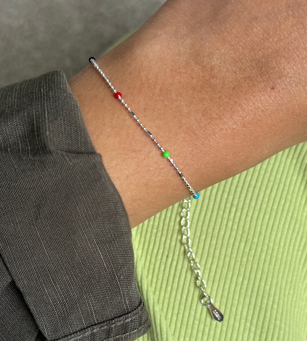 Colourful silver bead bracelet worn on wrist