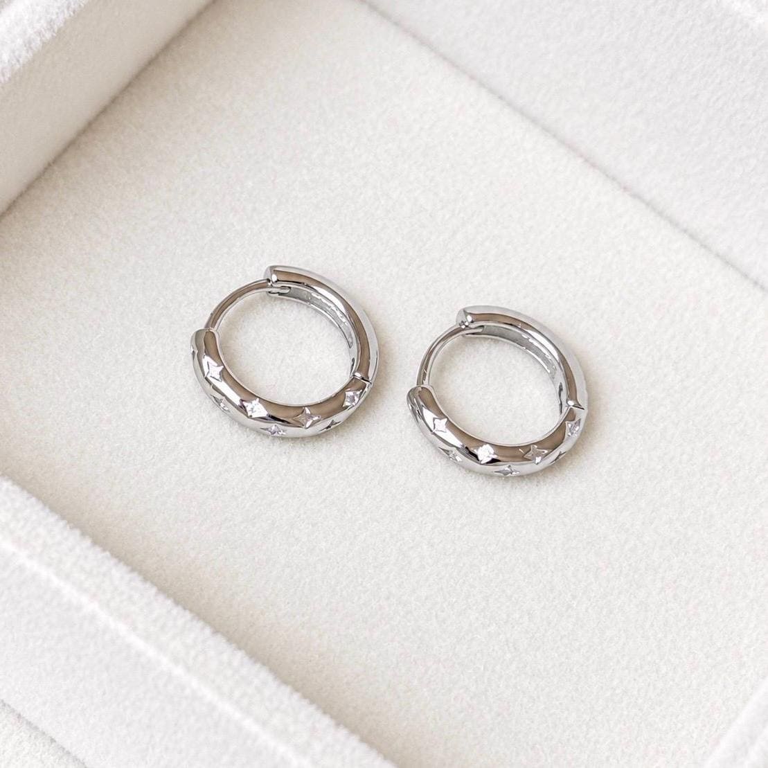 925 sterling silver celestial CZ star huggie hoops displayed on ivory velvet