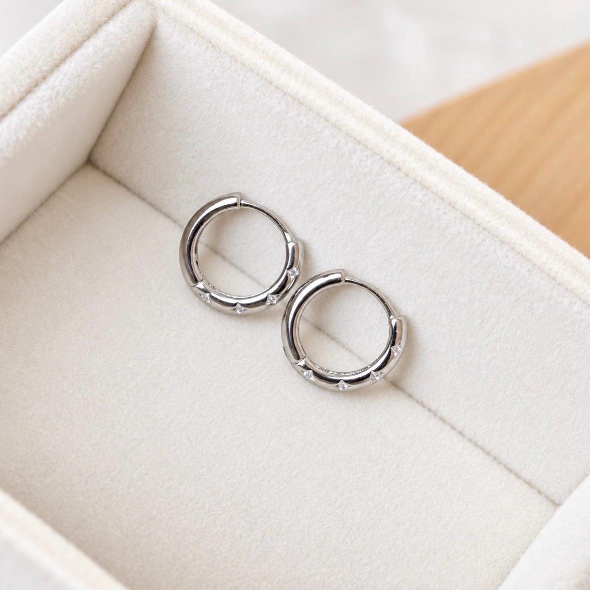 Pair of silver huggie hoops with star motifs and clear CZ accents
