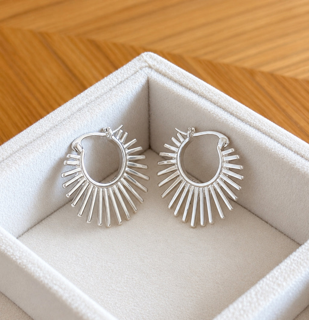 Front view of the silver sunburst hoop earrings in gift box