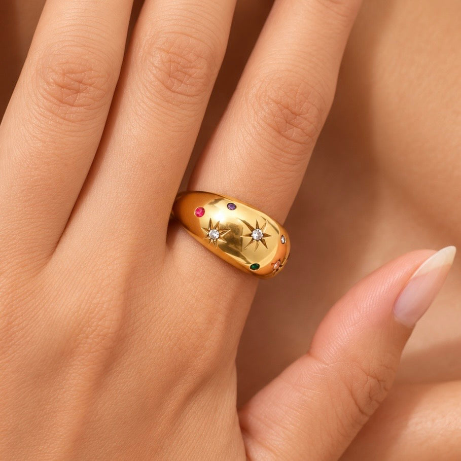 Gold-plated statement ring styled on a hand showing scale
