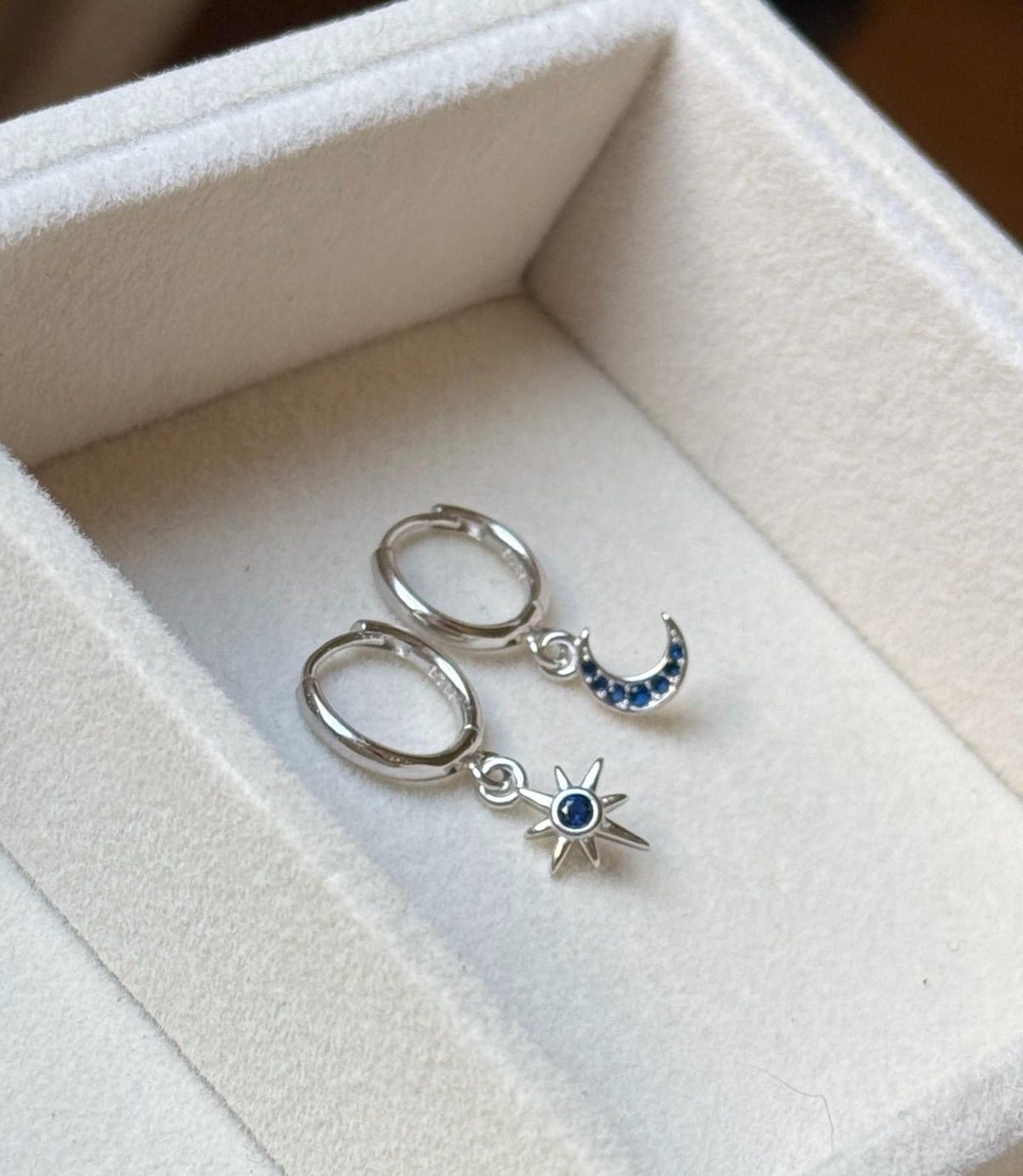 Silver celestial moon and star blue CZ huggies in jewellery tray