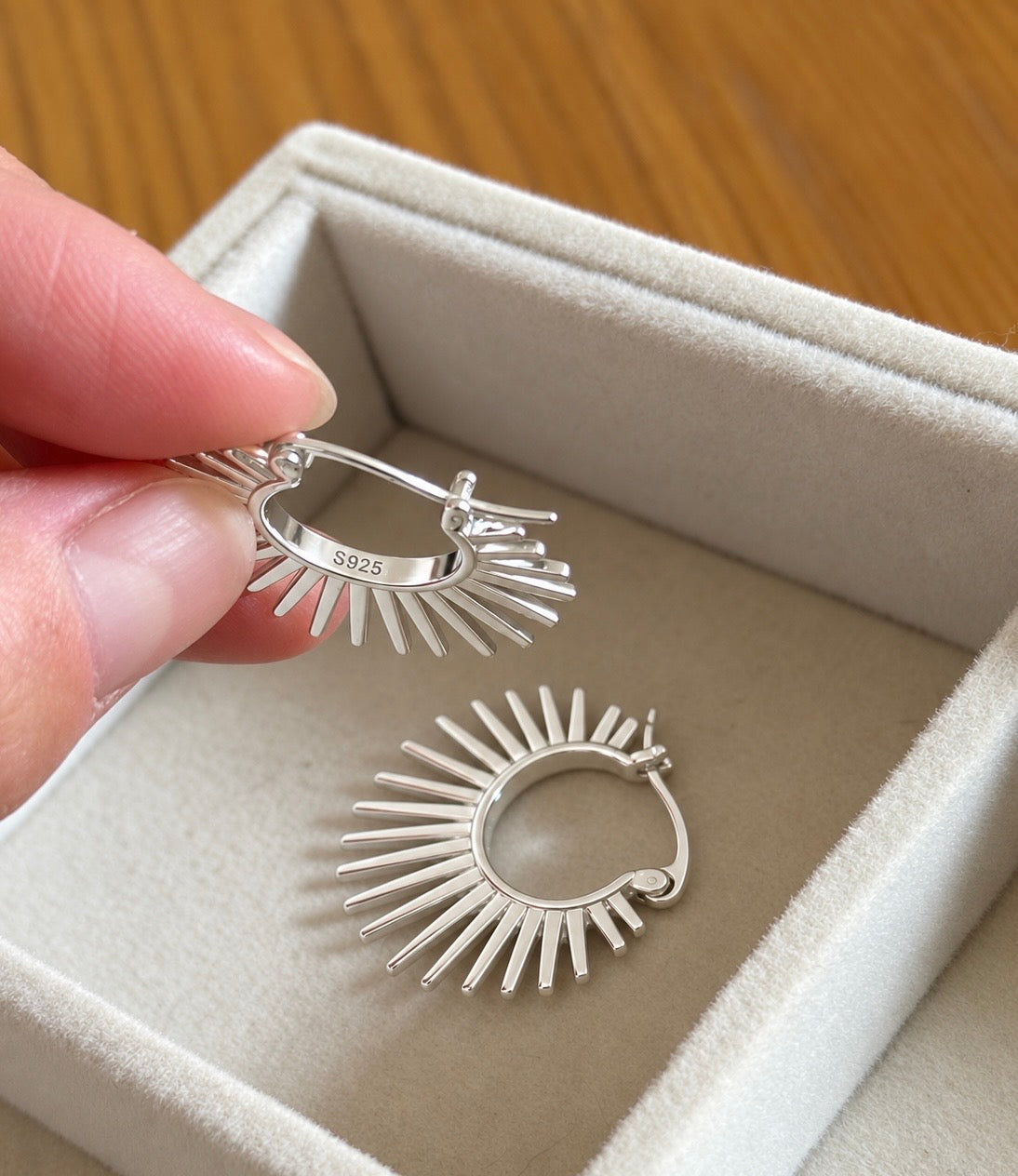 Close-up of S925 stamp inside the silver sunburst hoop earring
