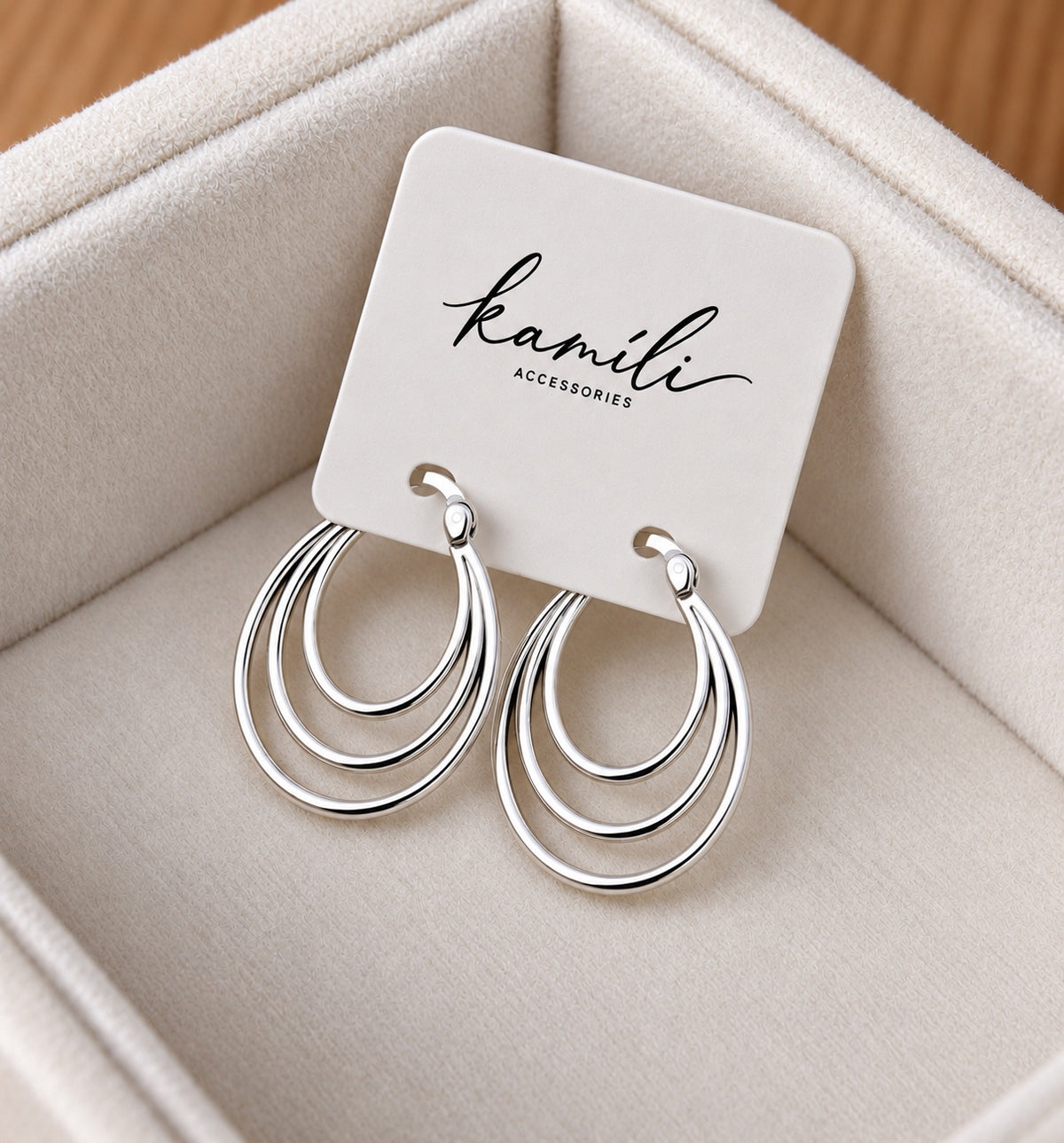 Triple oval sterling silver hoop earrings displayed on a Kamíli Accessories presentation card